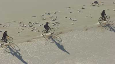 Salt gatherers riding bicycles on the salar