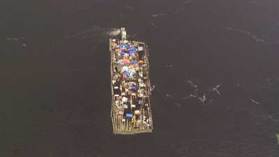 A half sunk raft-barge transports trunks