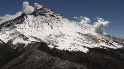 The snowy Popocatepetl, surrounded by blue sky and clouds