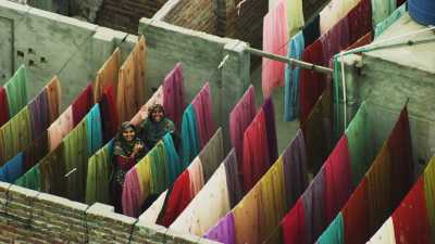 Women drying coloured laundry on the city  roofs